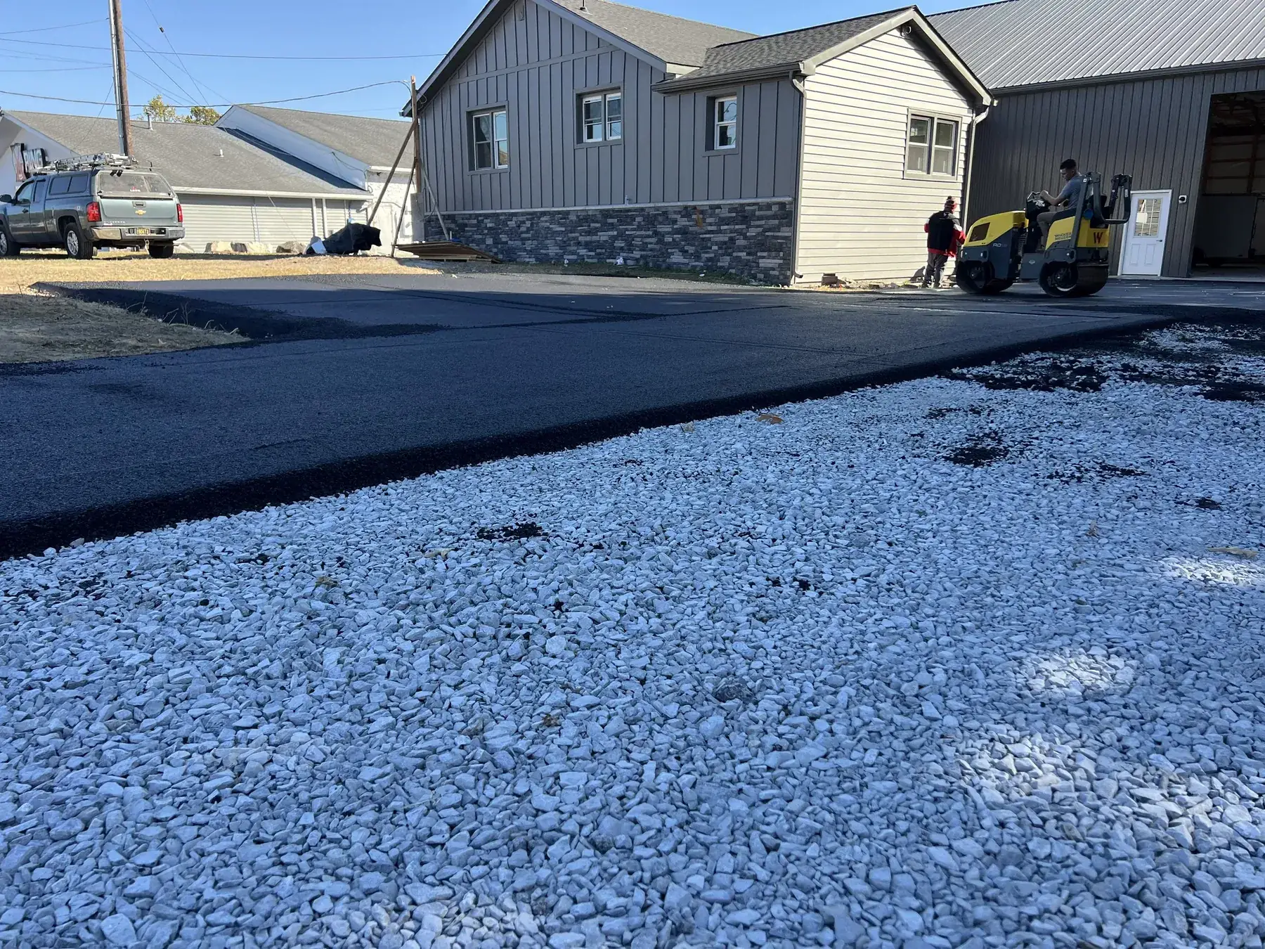 Crew rolling a new driveway over the stone base